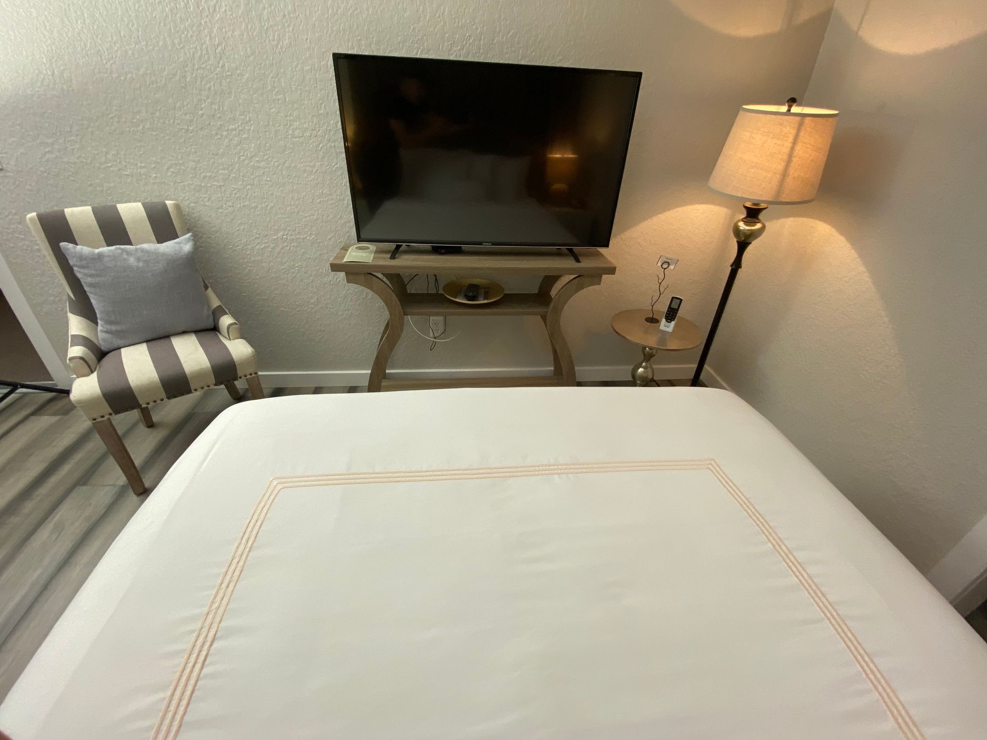 A bedroom with a bed a chair and a television