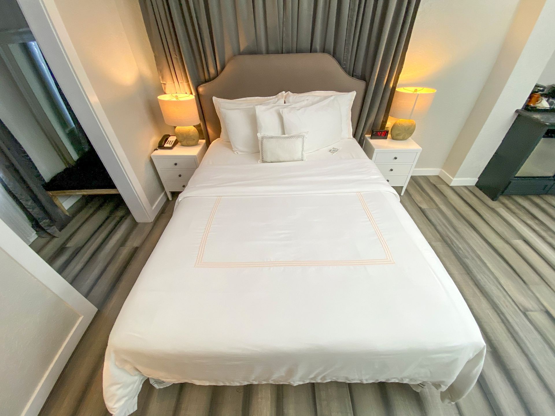 A bed with white sheets and pillows in a hotel room