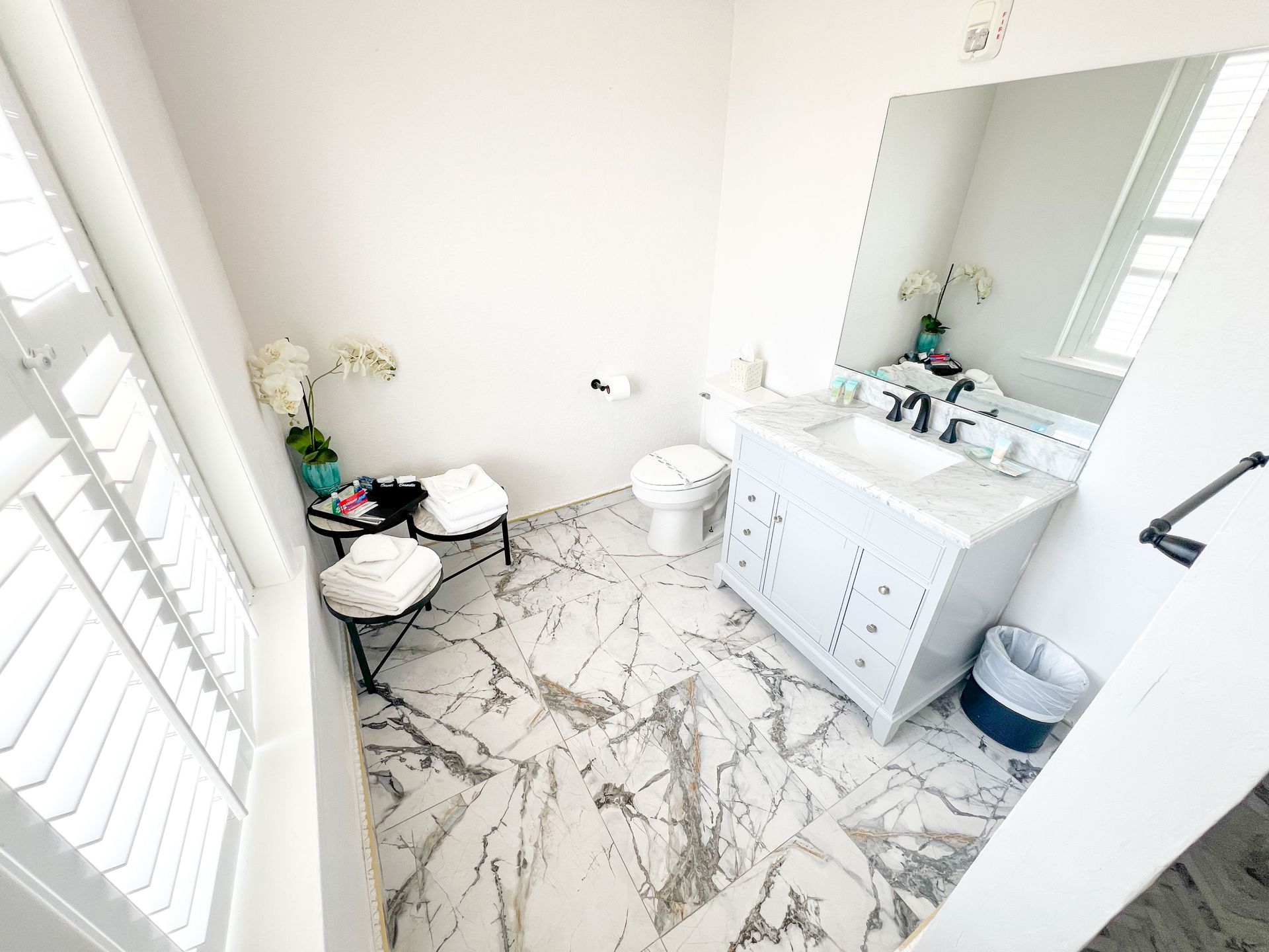 A bathroom with a sink , toilet and mirror.