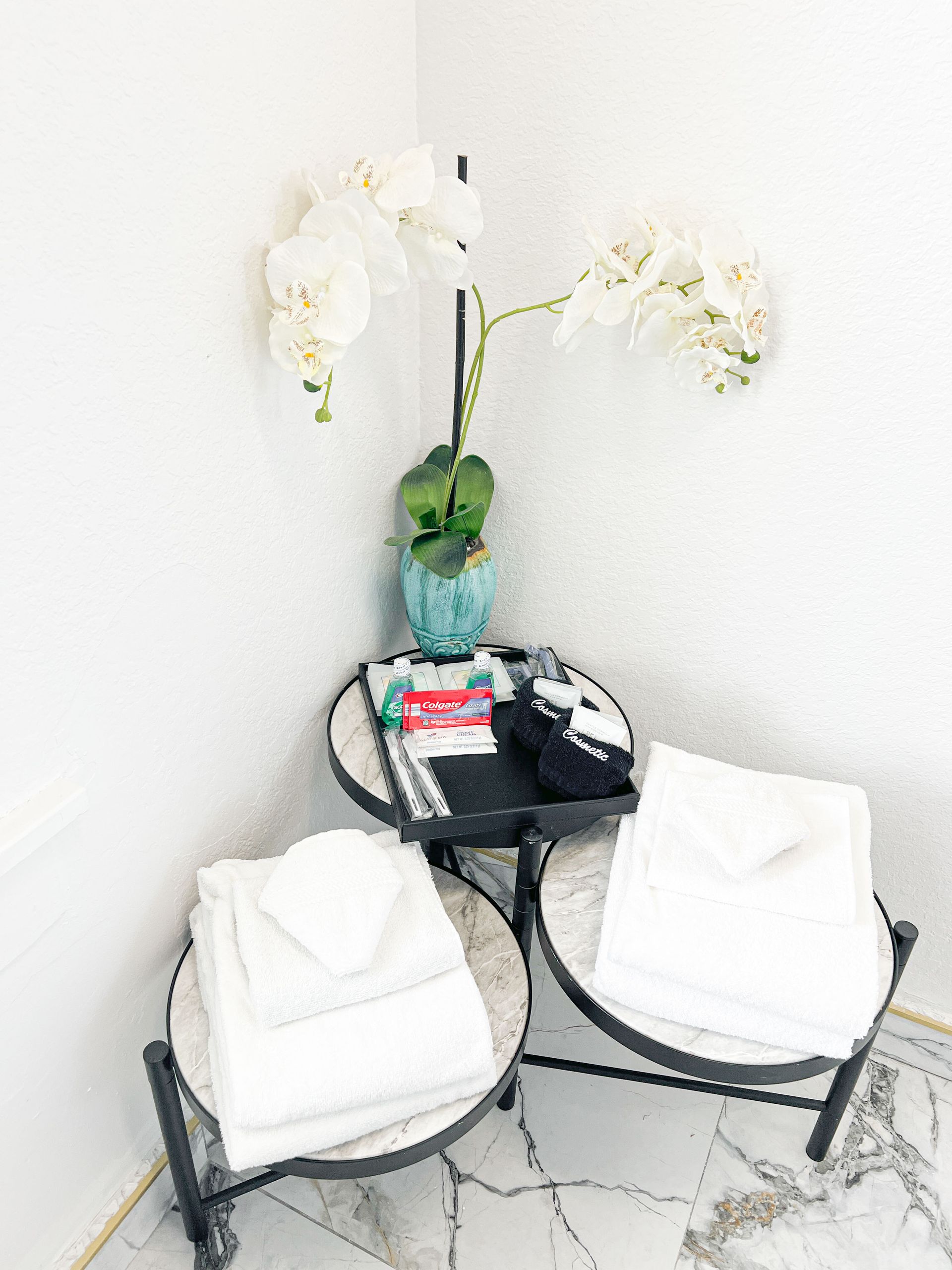 A table with towels and a flower on it in a bathroom.