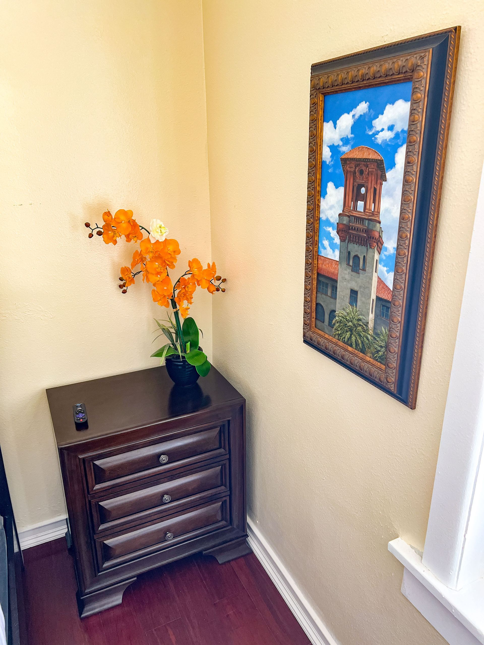 A room with a dresser and a picture on the wall