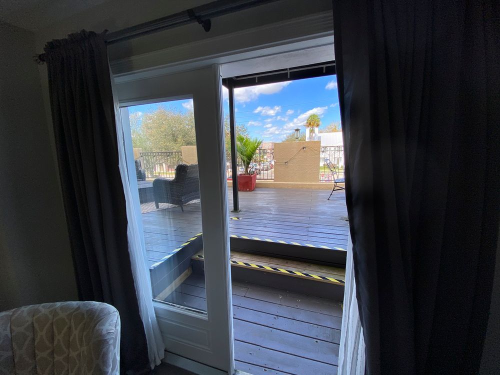 A room with a sliding glass door leading to a balcony.