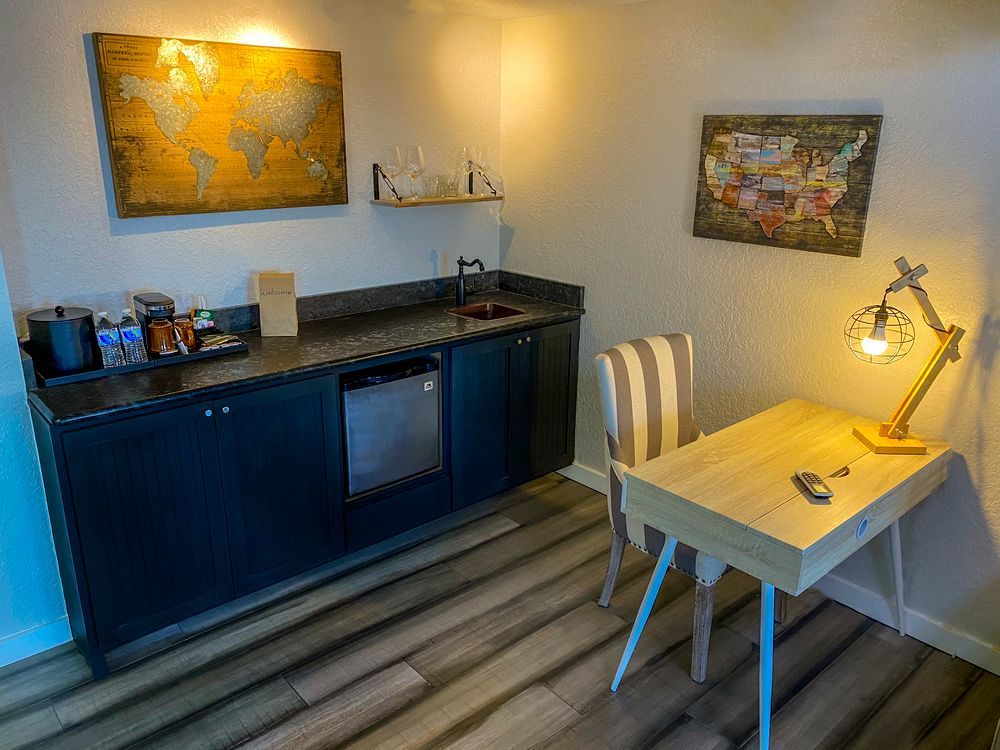 A small kitchen with a desk , chair , and dishwasher.