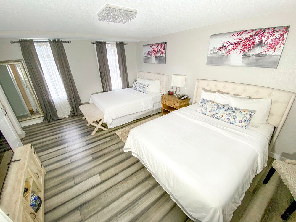 A bedroom with two beds , a dresser and a mirror.