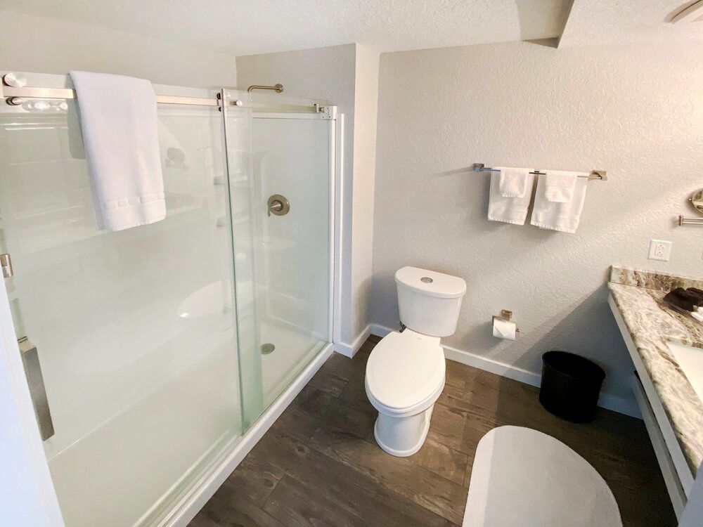 A bathroom with a toilet , sink , shower and bathtub.