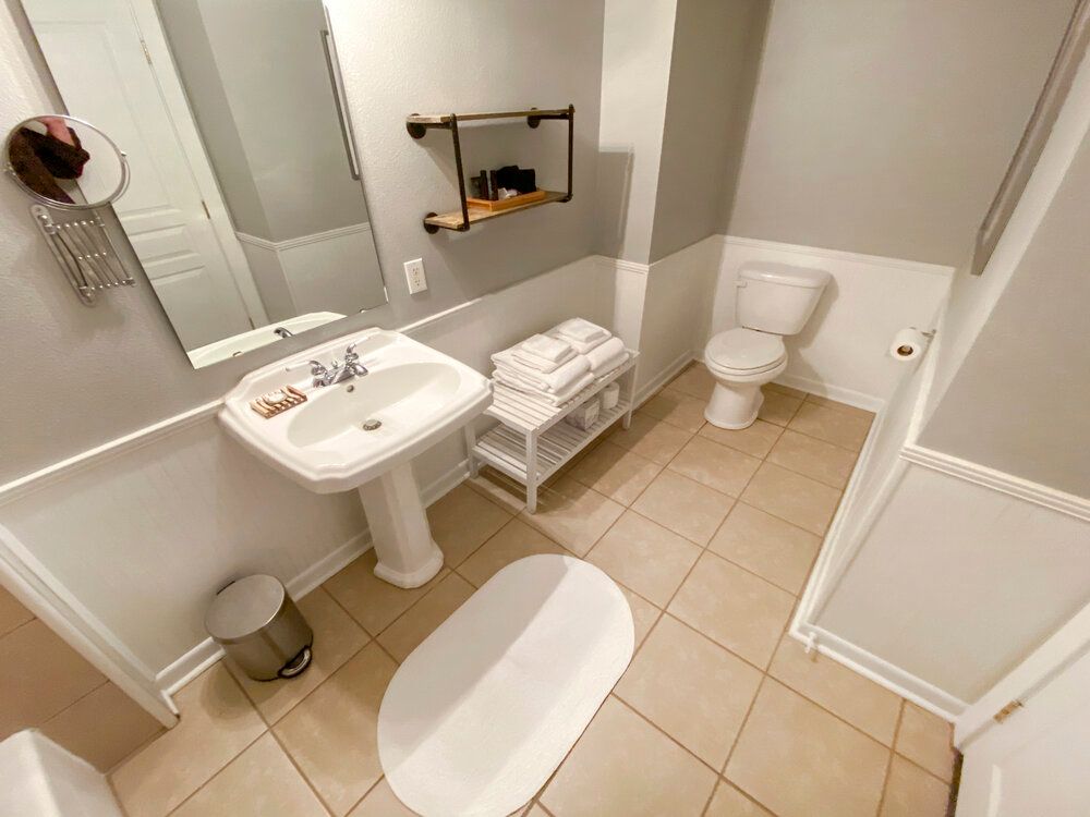 A bathroom with a sink , toilet and mirror.