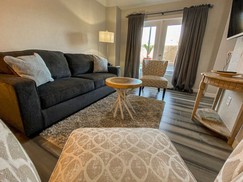 A living room with a couch , chairs , table and television.