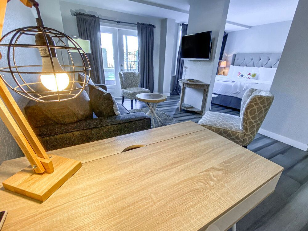 A lamp is sitting on a wooden table in a hotel room.