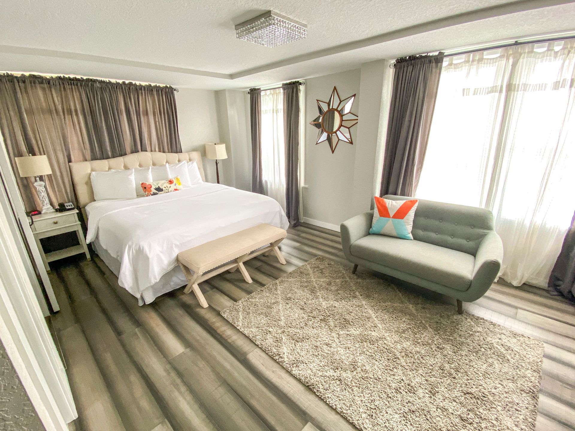 A bedroom with a large bed , couch , and rug.