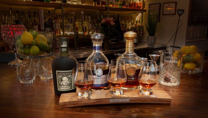 A wooden table topped with bottles of liquor and glasses.