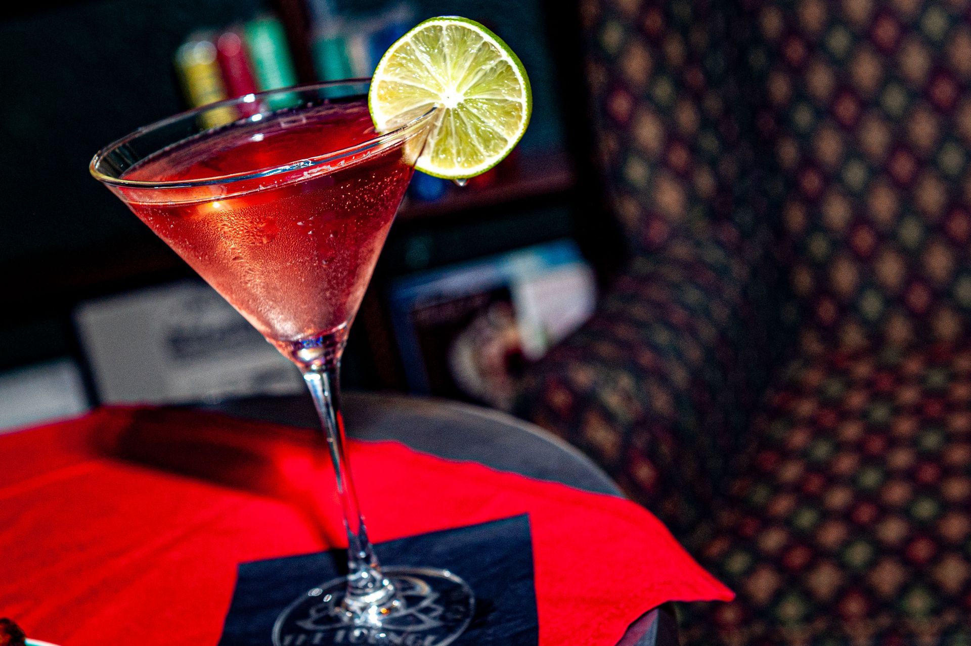 A martini glass with a slice of lime on top of it.