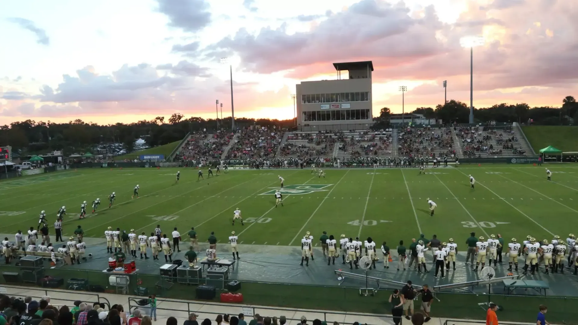 A football field with a large stadium in the background
