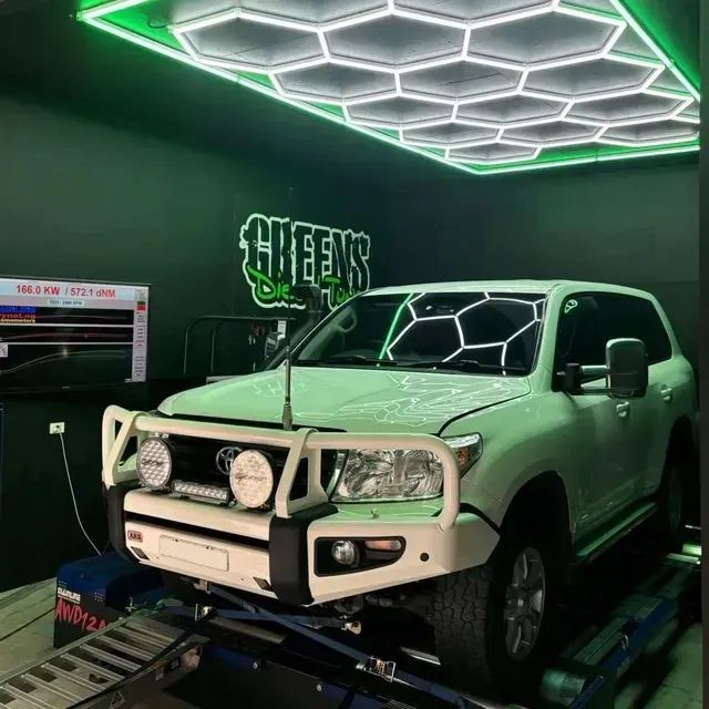 White Suv Inside a Shop With Green Accents and Hexagon Lights Overhead — Greens Diesel Tune in Narellan, NSW