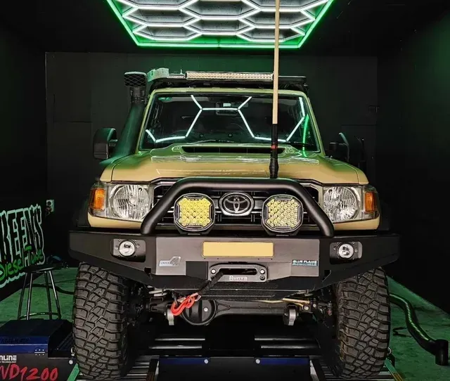 Tan Toyota Land Cruiser on a Dyno, Surrounded by Green Lighting — Greens Diesel Tune in Smeaton Grange, NSW