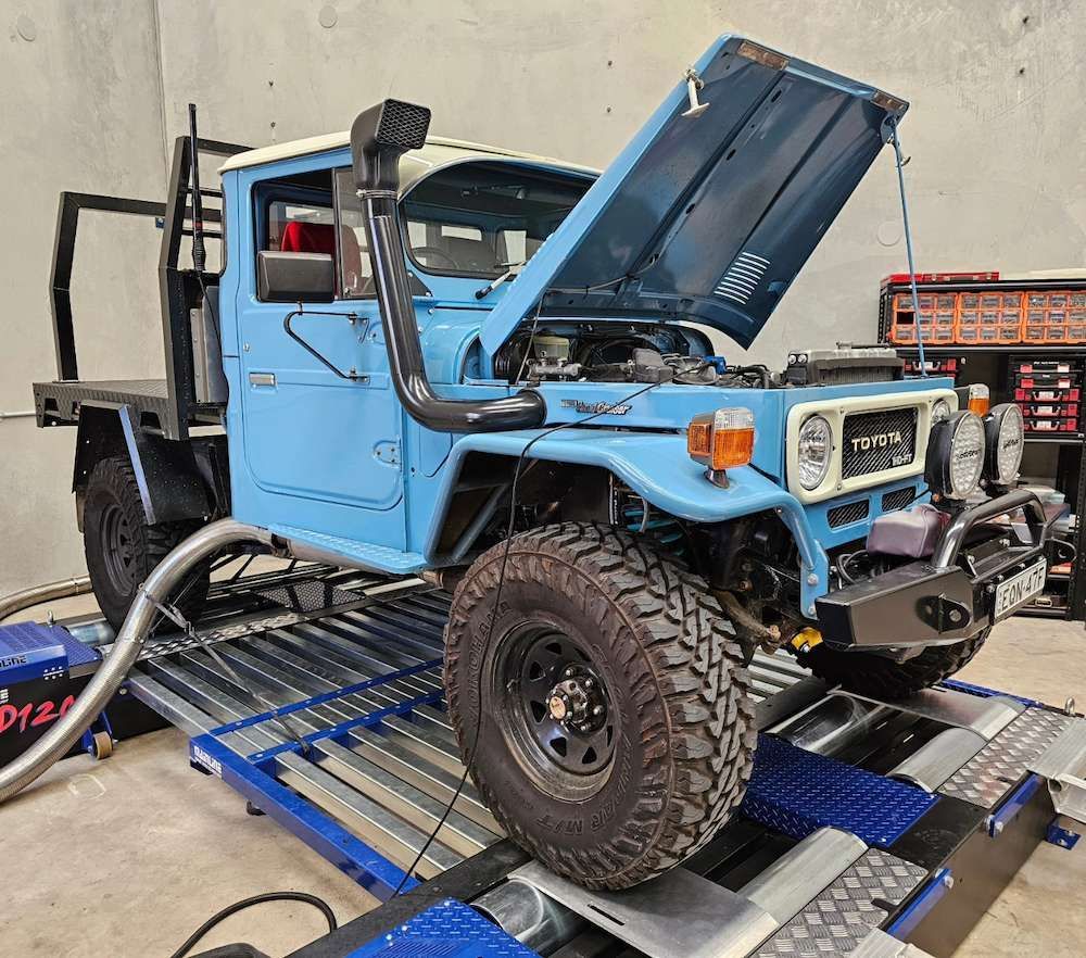 Blue Toyota Land Cruiser on a Dynamometer With Hood Open — Greens Diesel Tune in Campbelltown, NSW