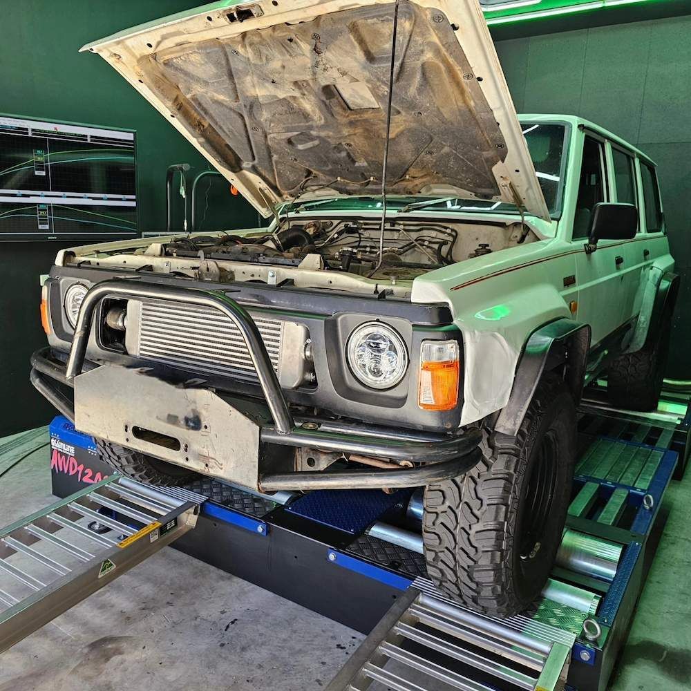 White Off-road Vehicle With Open Hood on a Dyno in a Garage — Greens Diesel Tune in Smeaton Grange, NSW
