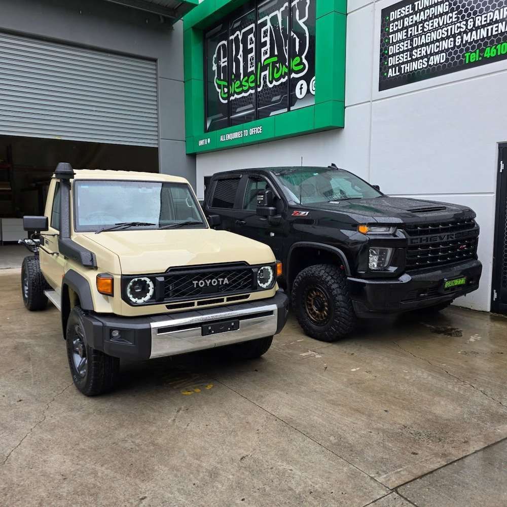 Tan Toyota Land Cruiser and Black Chevrolet Truck Parked Outside — Greens Diesel Tune in Smeaton Grange, NSW