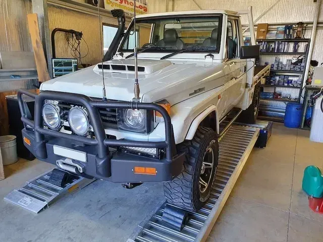 White Toyota Land Cruiser Pickup Truck on Ramps Inside a Garage
 — Greens Diesel Tune in Camden, NSW