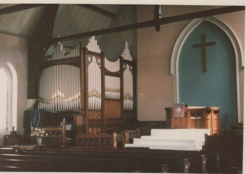 Inside Wharton Presbyterian Church 1900-1969, showing the pulpit, cross & pipe organ.