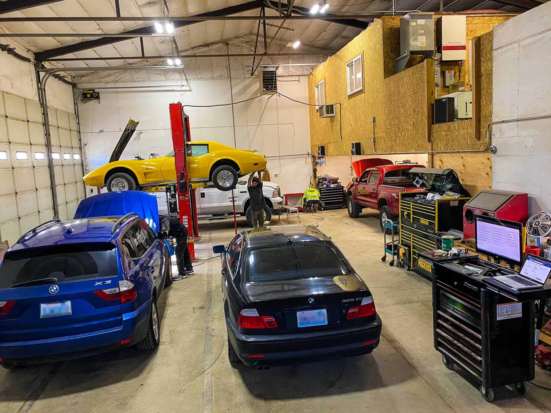 A brightly lit auto repair shop with several vehicles | Karraker Mechanical Solutions