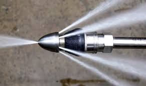 Sewer jet nozzle spraying water forcefully.