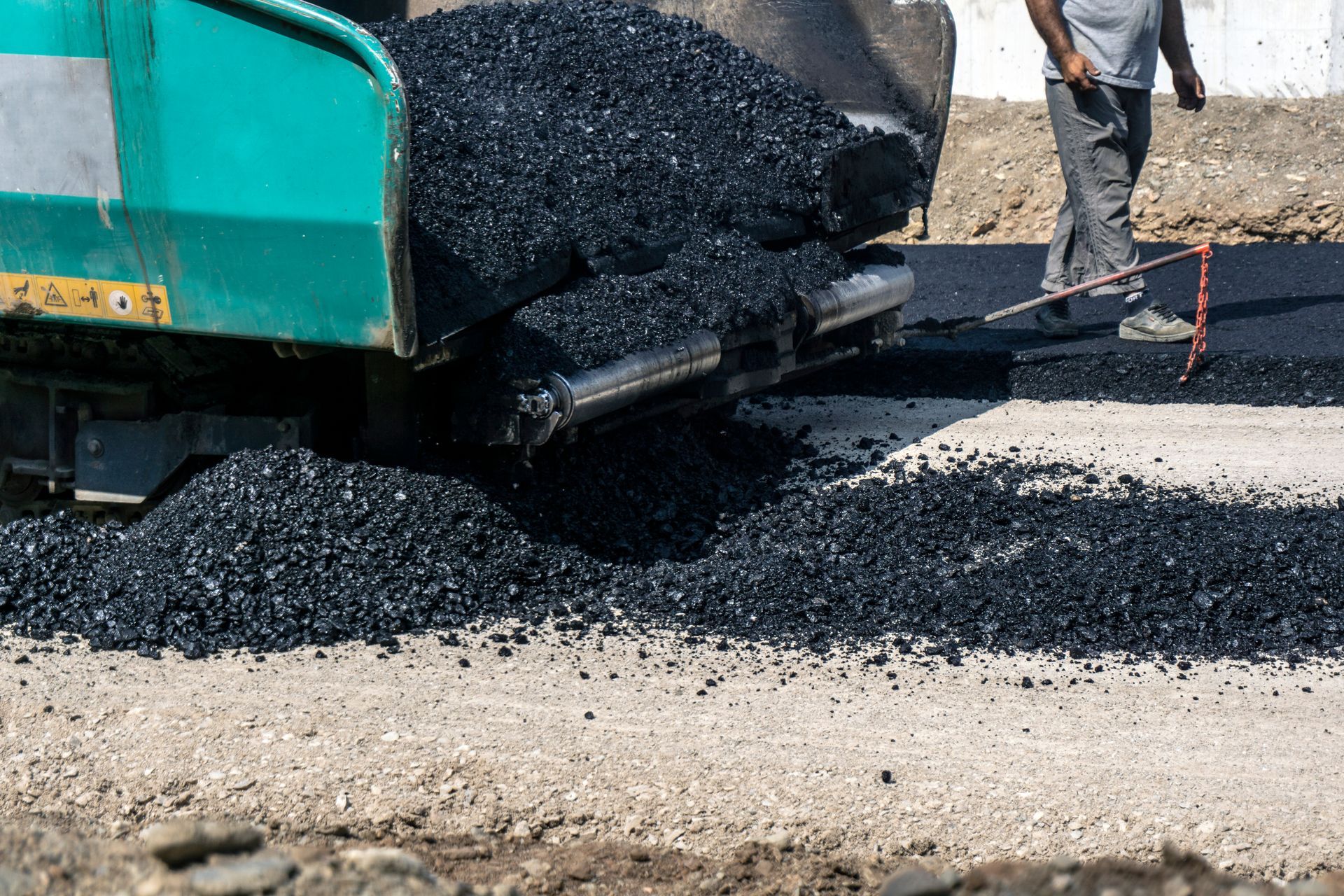 Dump truck unloading fresh asphalt onto a road surface