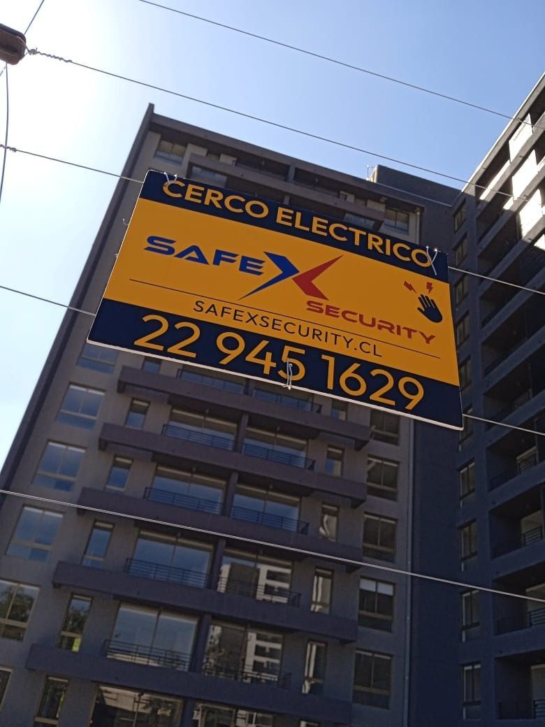 Letrero de la empresa de seguridad de cercas eléctricas SafeX Security en el exterior de un edificio; esquema de colores azul y amarillo.
