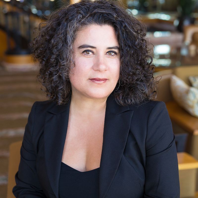 A woman with curly hair is wearing a black jacket