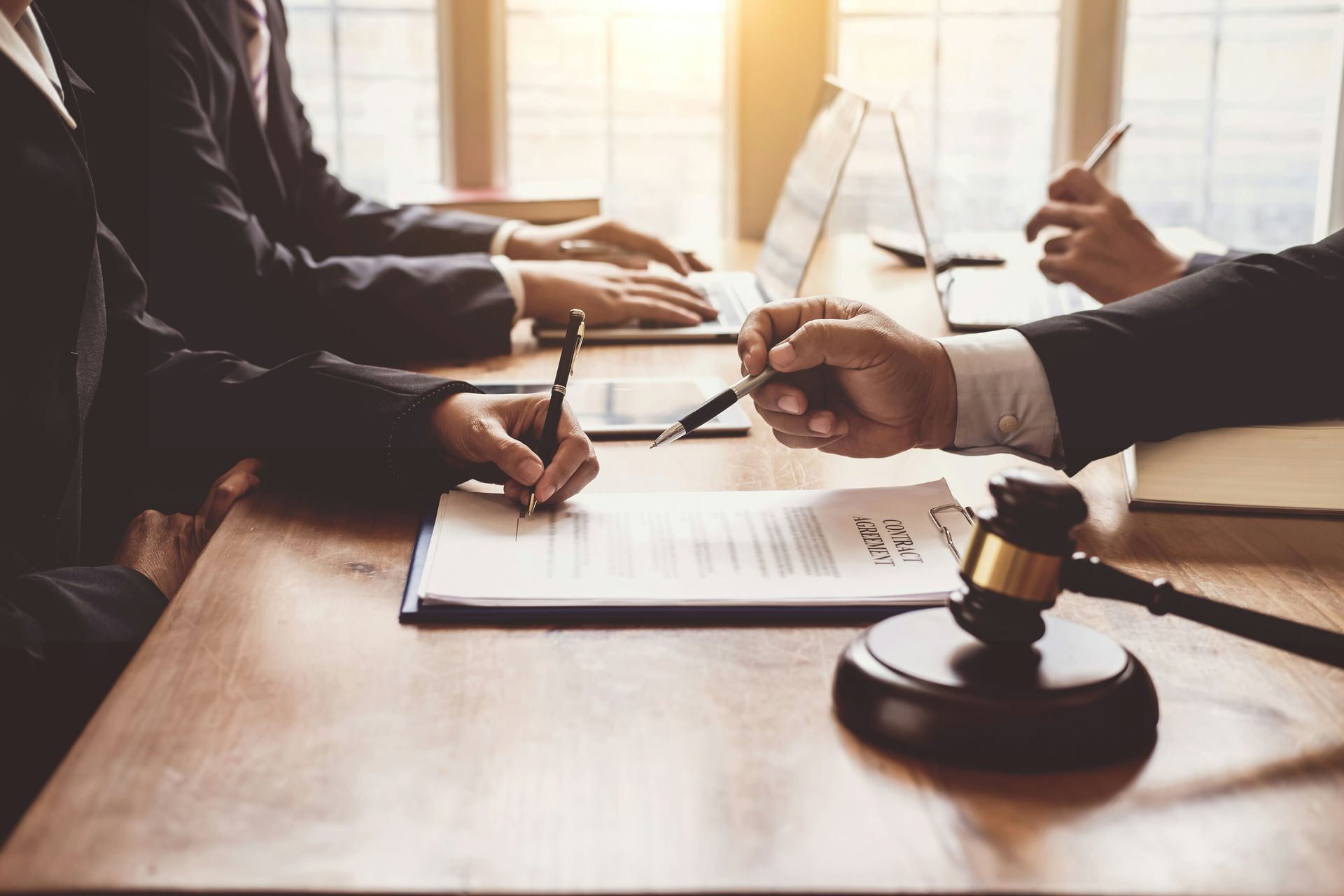 A group of people are sitting at a table with a judge 's gavel.