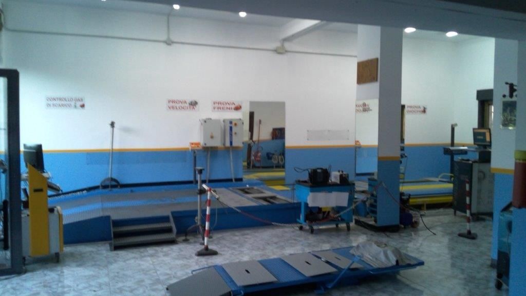 Serbatoi metallici cilindrici con targhette ed etichette su uno scaffale di legno.