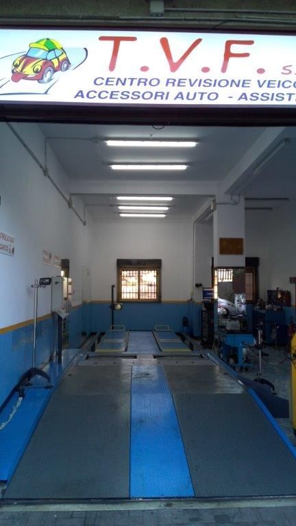 Primo piano di tubi industriali, alcuni neri e altri rossi, appesi a una struttura metallica.