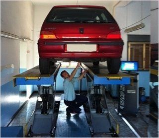 Bancone della reception in legno con il logo aziendale su una parete dalla texture scura, illuminato dall'alto.