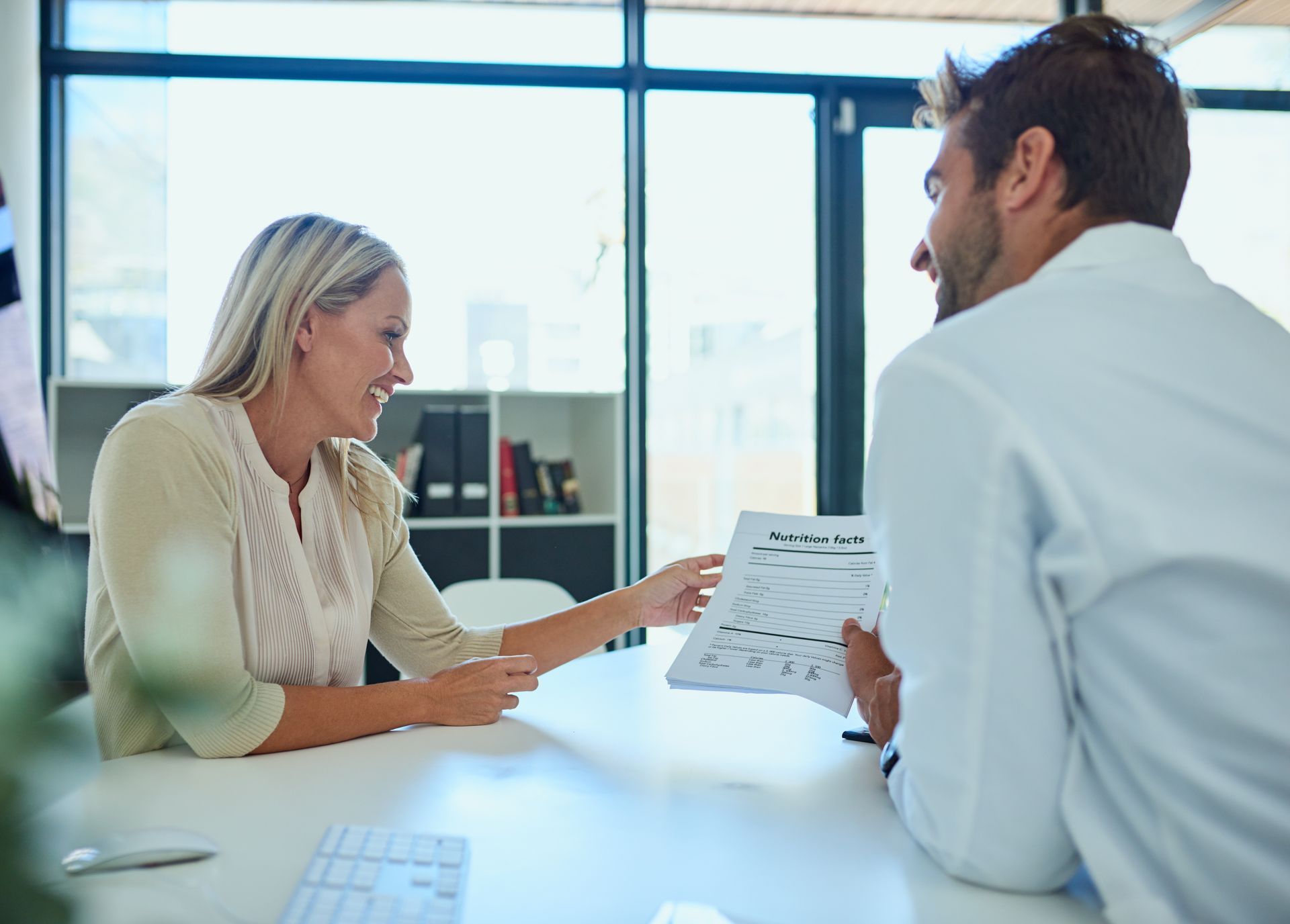 People in a business meeting around a table, using laptops and discussing ideas.