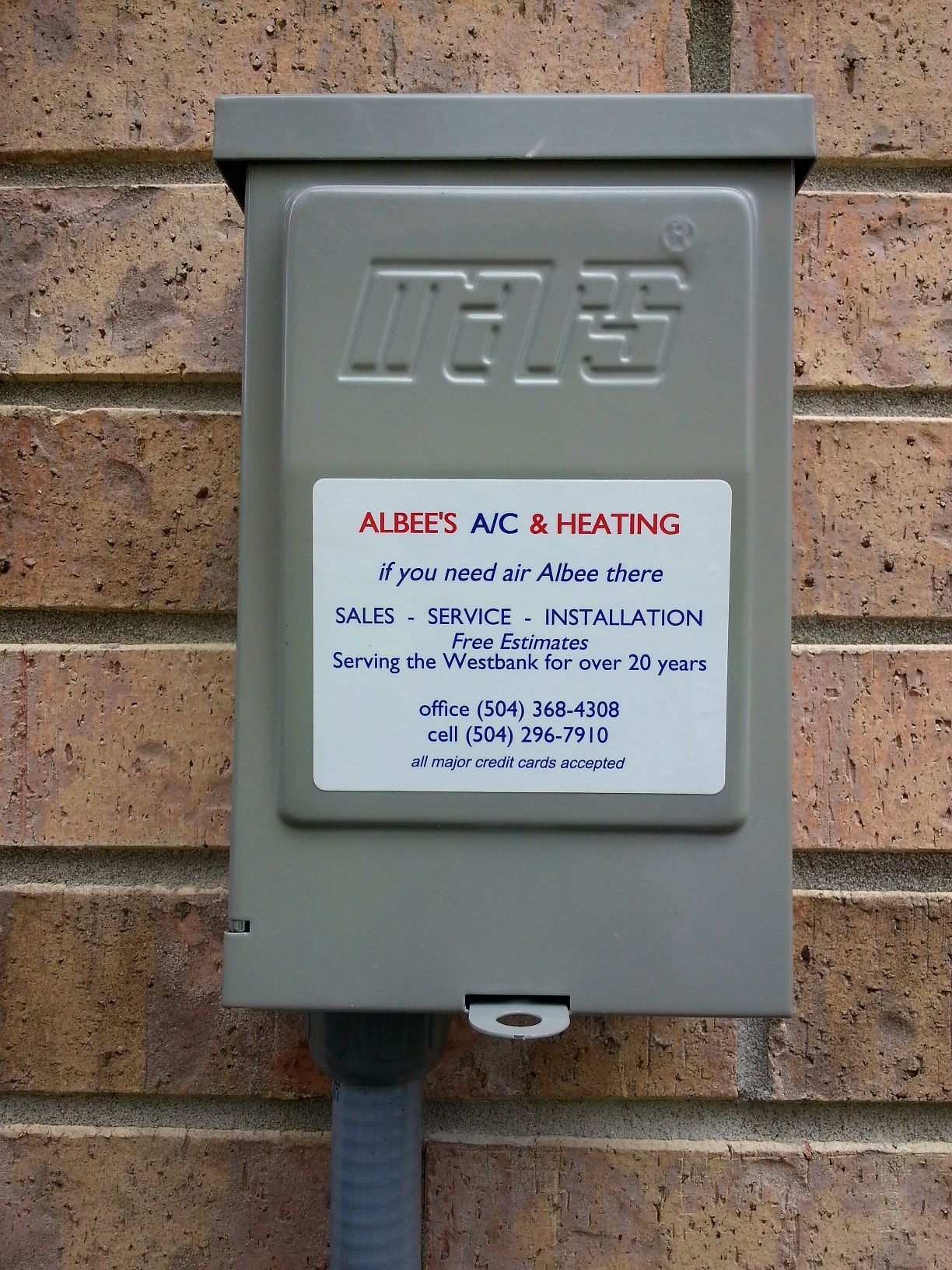 A box on a brick wall that says ' albert 's ac & heating ' on it