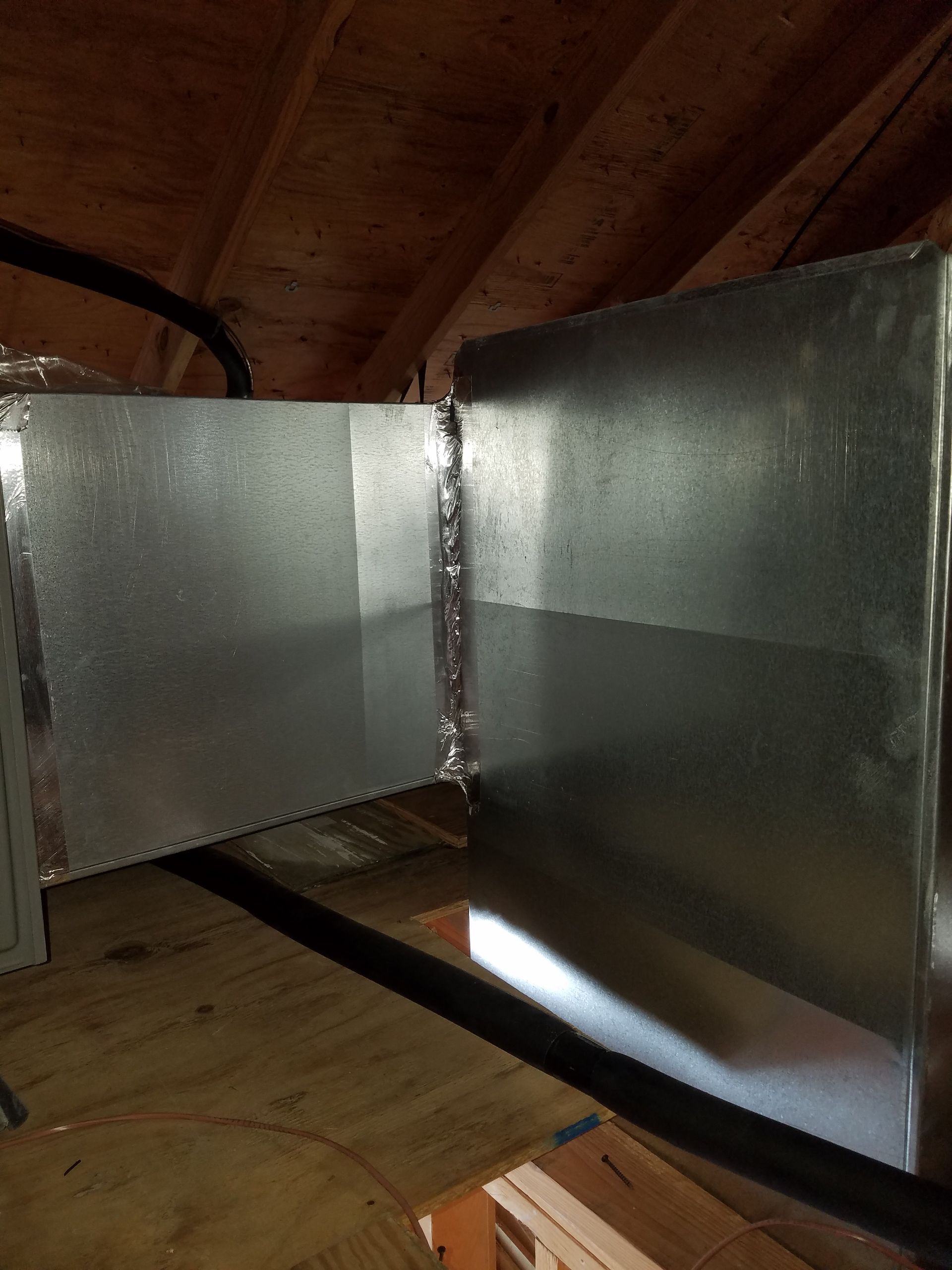 A metal pipe is hanging from the ceiling of a room.