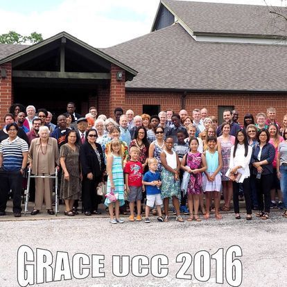 A large group of people are posing for a picture in front of a building.