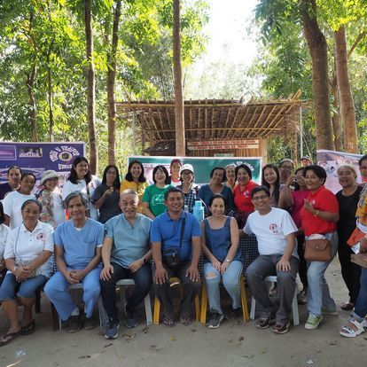 A group of people are posing for a picture in a park.