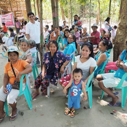 A group of people are sitting in chairs in a park.