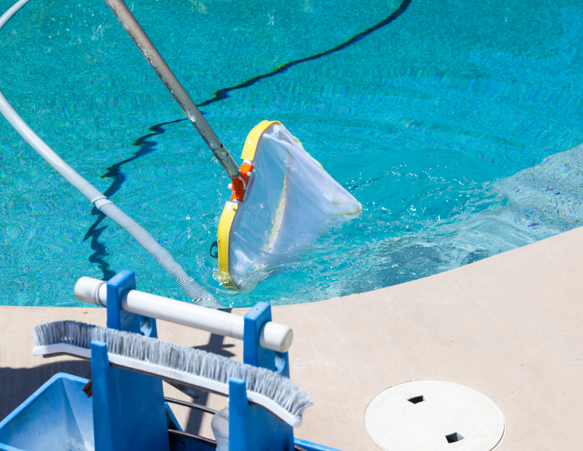 A cleaning device is being used to clean a swimming pool