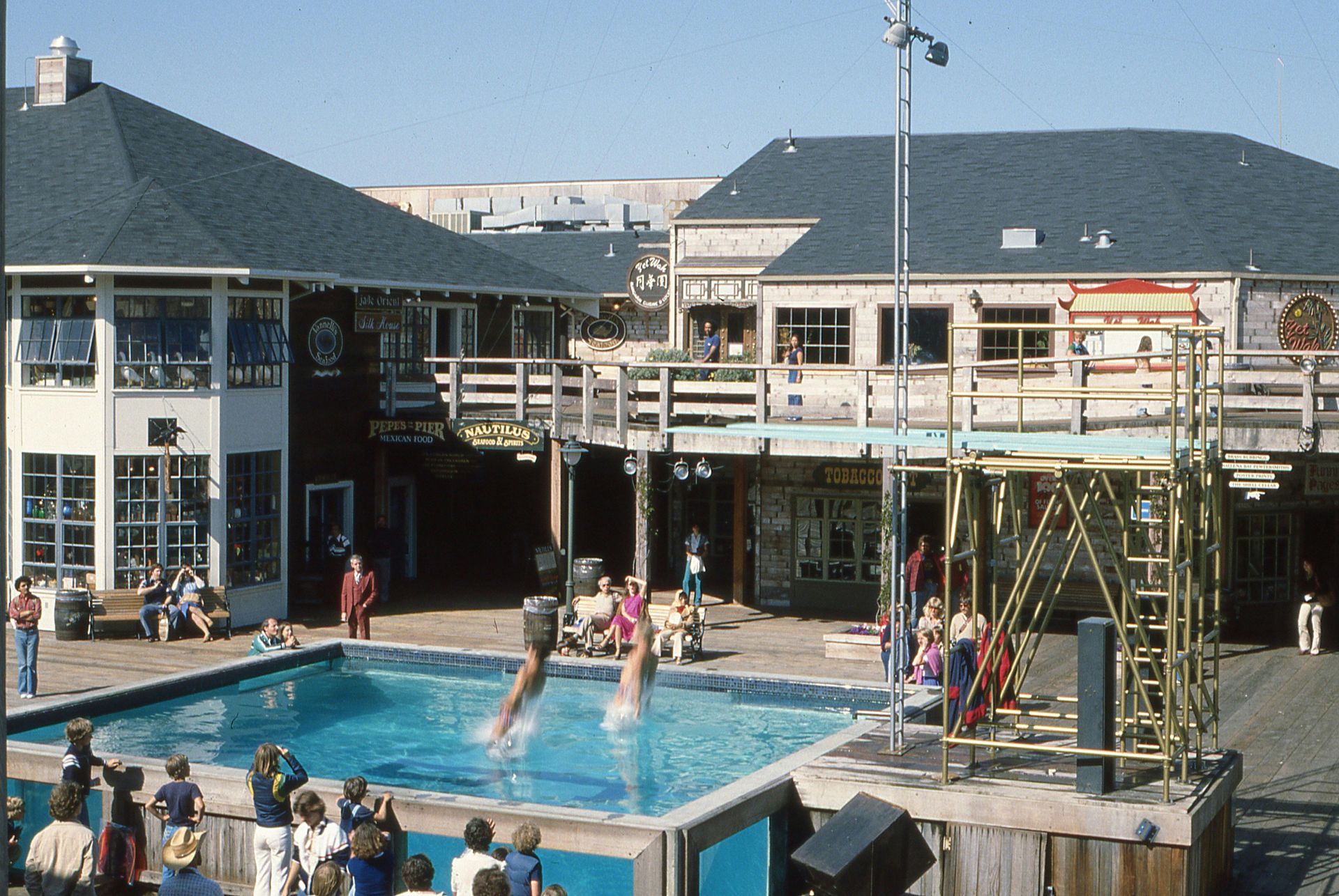 A group of people are gathered around a swimming pool