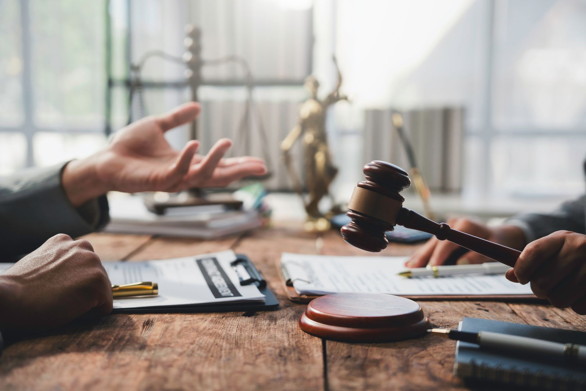 A criminal defense lawyer discussing a case with a gavel and documents on a desk.