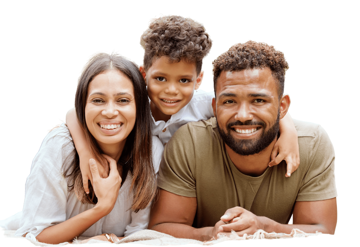 a family is laying on a blanket together and smiling for the camera .