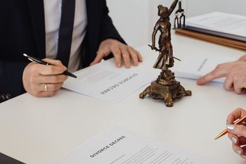 a man and a woman are sitting at a table with a statue of justice .