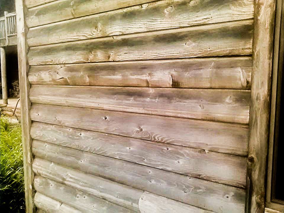 a close-up of a log cabin wall with a window