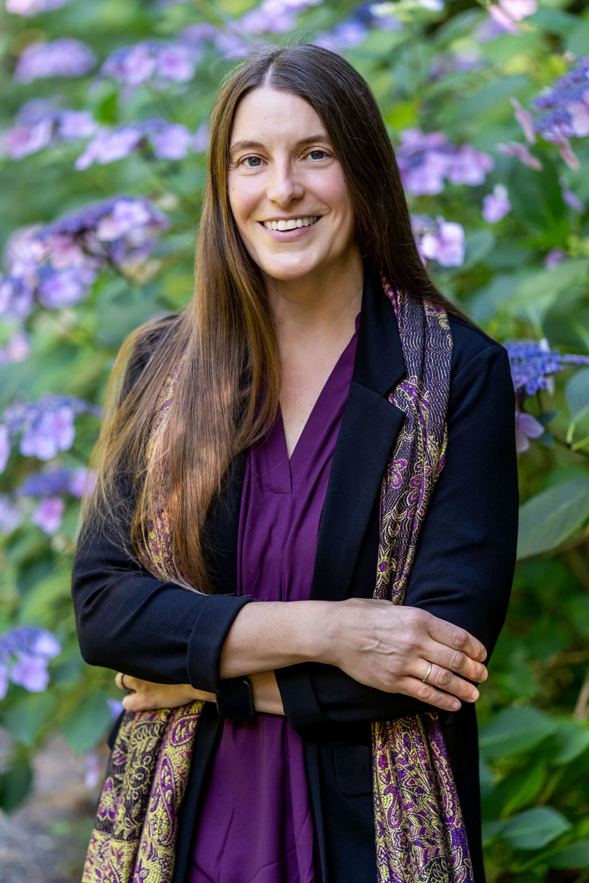 A headshot of Callie Vogel with flowers in the background