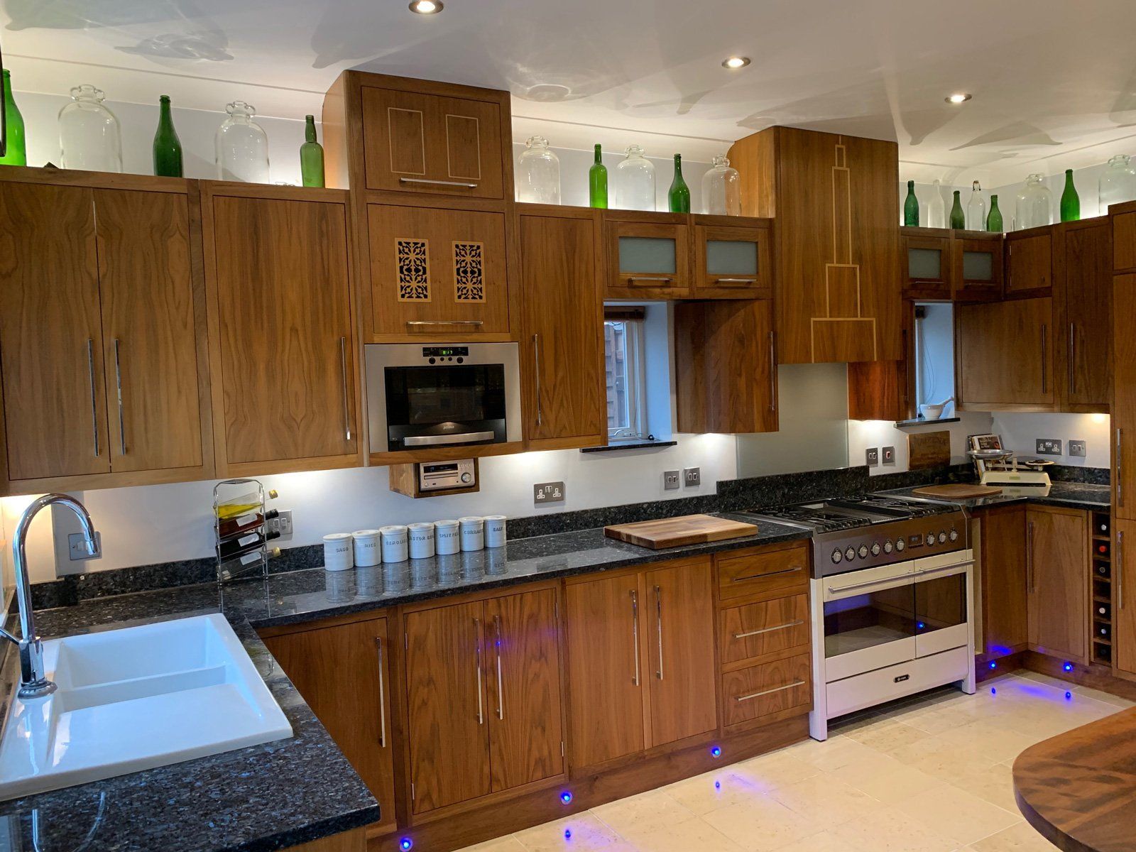 A kitchen with wooden cabinets , granite counter tops , a sink , and a stove.