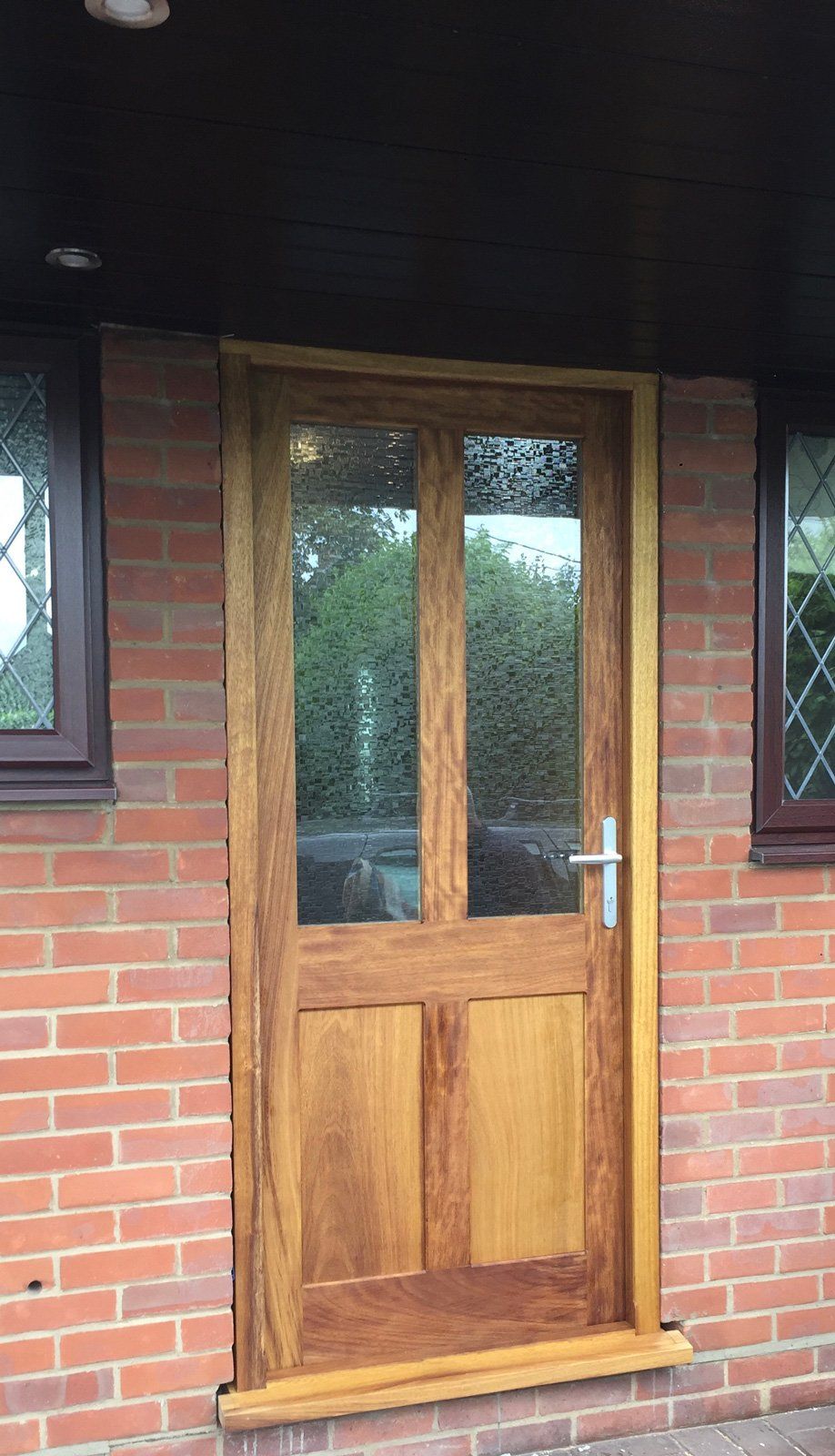A wooden door is sitting on top of a brick wall.
