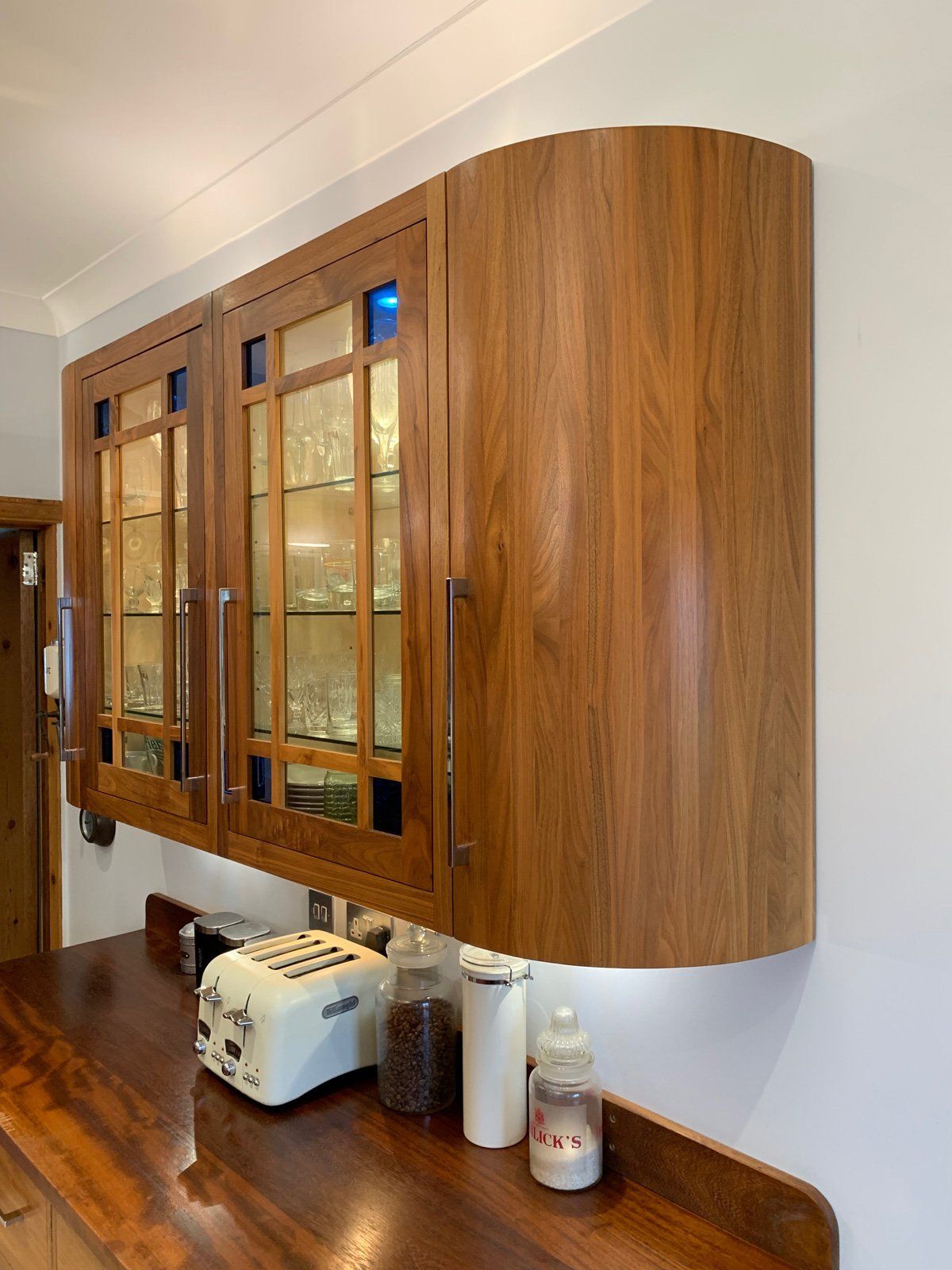 A kitchen with wooden cabinets and a toaster oven on the counter.