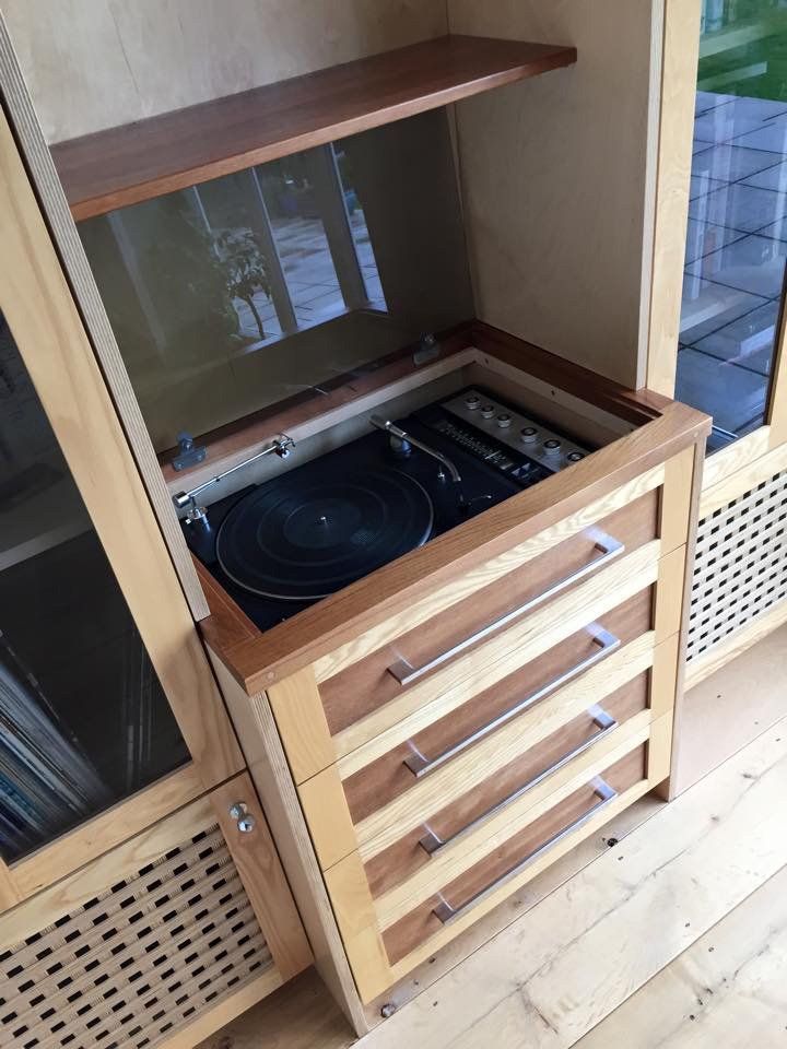 A record player is sitting inside of a wooden cabinet