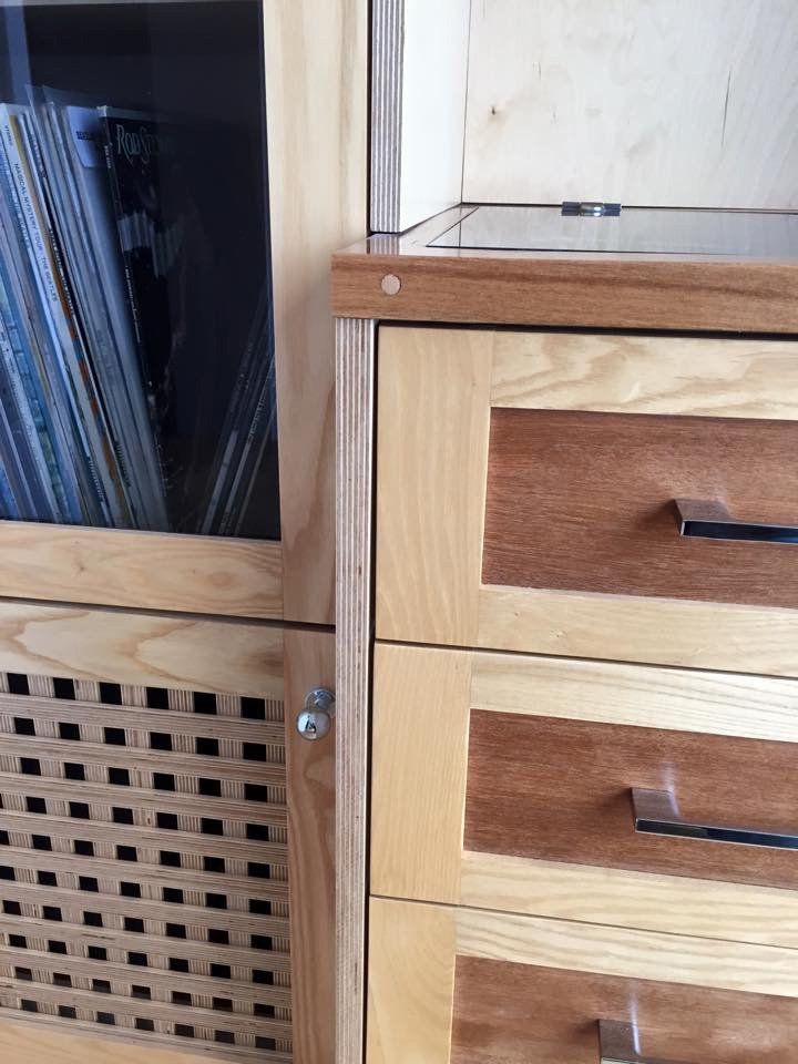 A wooden dresser with three drawers and a glass door